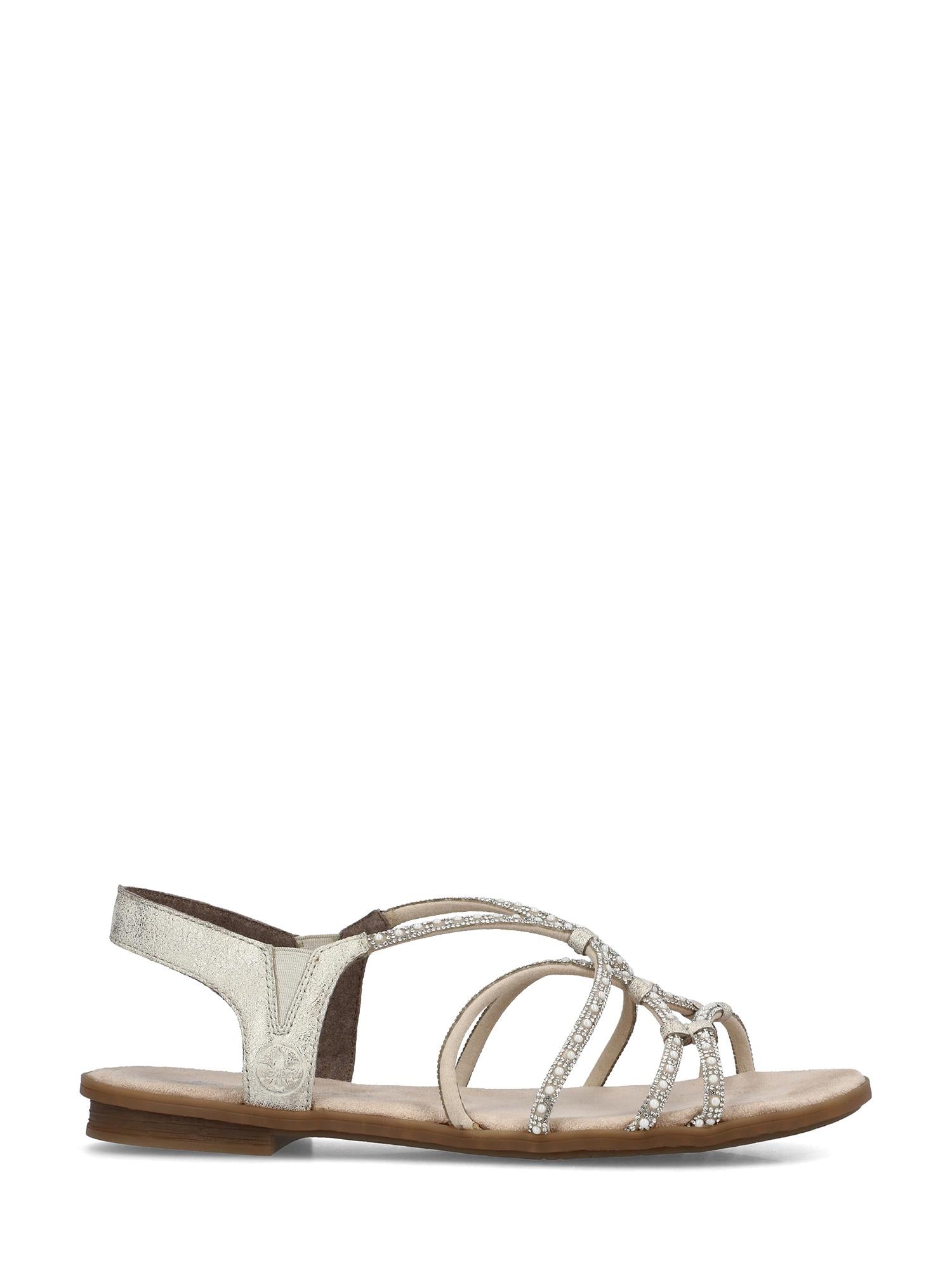 02997 Rieker Sienna Soft Sandal fra Rieker Comfort & Style er en elegant damesandal med beige såle, ankelrem i sølvmetallic og krysskryssede remmer med rhinestone for stilig komfort med åpen tå og lav hæl.