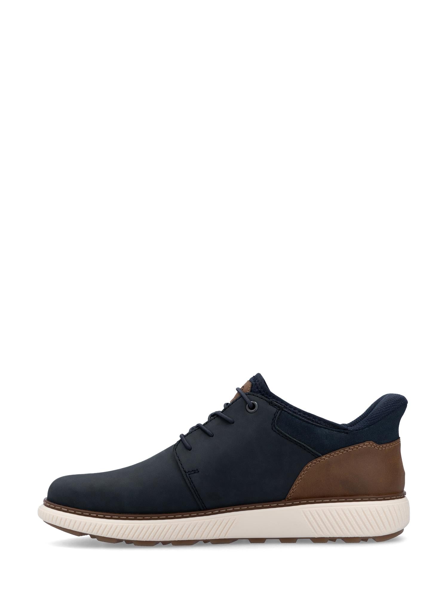 03056 Rieker Navy Wide Comfort Slip-on fra Rieker Comfort & Style, med marineblå og brun overdel, svarte lisser, en hvit, sklisikker såle med tekstur og lavt snitt, er vist i sideprofil mot en hvit bakgrunn.