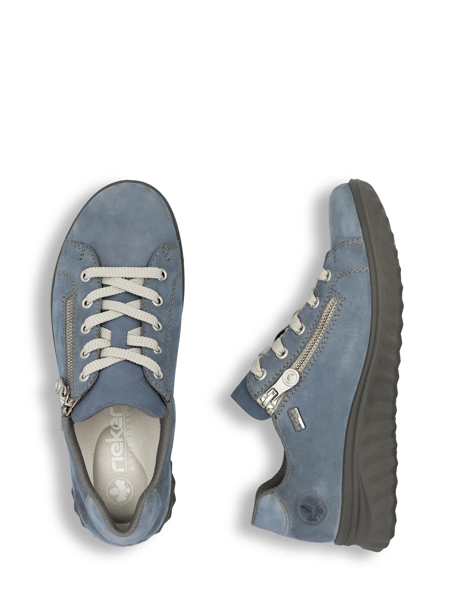 02975 Rieker AquaFlex skinnsneakers fra Rieker Comfort & Style: blå, hverdagslige sneakers med hvite lisser, glidelås på siden, svarte teksturerte såler og antistressteknologi for komfort hele dagen. Én sko sett ovenfra, den andre sett fra siden.