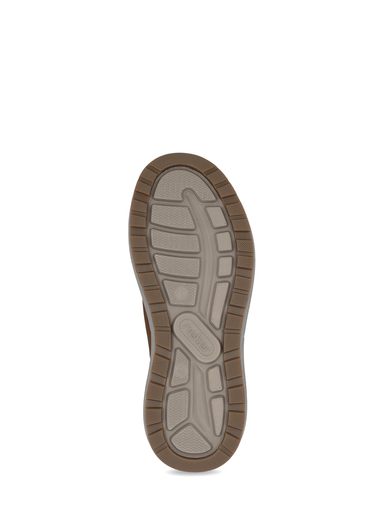 Et nærbilde av 04217 Rieker Harrison Ready2Go Slip-On fra Rieker Comfort & Style viser den lysegrå, teksturerte gummisålen med brune kanter, med ulike riller og mønstre som gir godt grep.