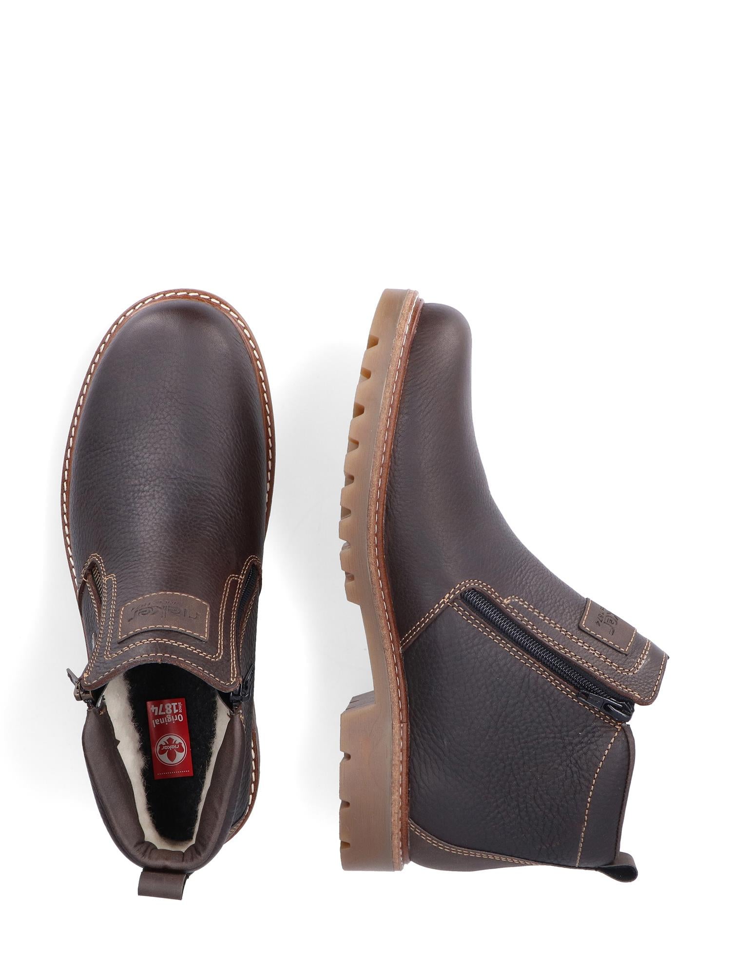 Et par 04984 Rieker Leather Fiber-Grip ullfôret ankelstøvler for menn fra Rieker Comfort & Style, i brunt skinn med glidelåser på siden og beige sømmer. De vannavvisende skoene har lyse såler, dype slitebaner og en rød etikett på innsiden av den ene støvelen.