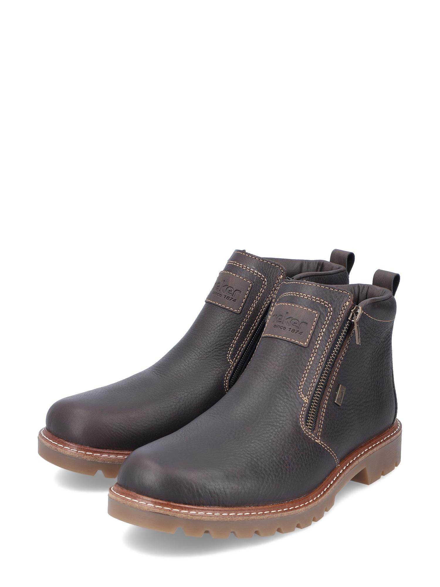 Et par mørkebrune 04984 Rieker Leather Fiber-Grip ullfôret ankelstøvler fra Rieker Comfort & Style, med glidelåser på siden, lysebrune sømmer, teksturerte såler og trekkfliker i hælen - perfekt som vinterstøvler herre.