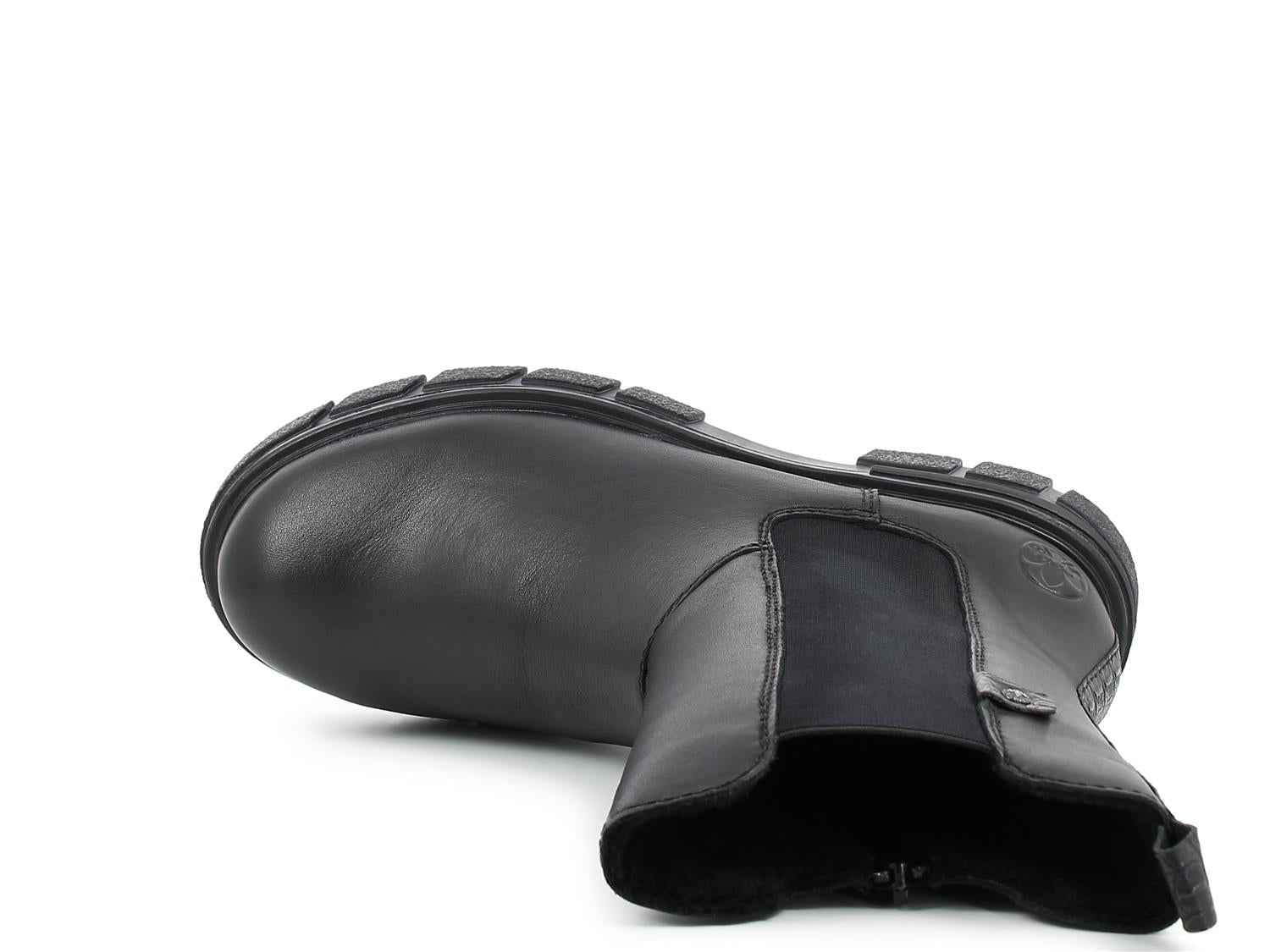 En enkelt 03046 Rieker Classic vinter chelsea varmfôret støvlett i skinn fra Rieker Comfort & Style ligger på siden og viser sålen, det elastiske sidepanelet og trekkfliken bak mot en vanlig hvit bakgrunn.