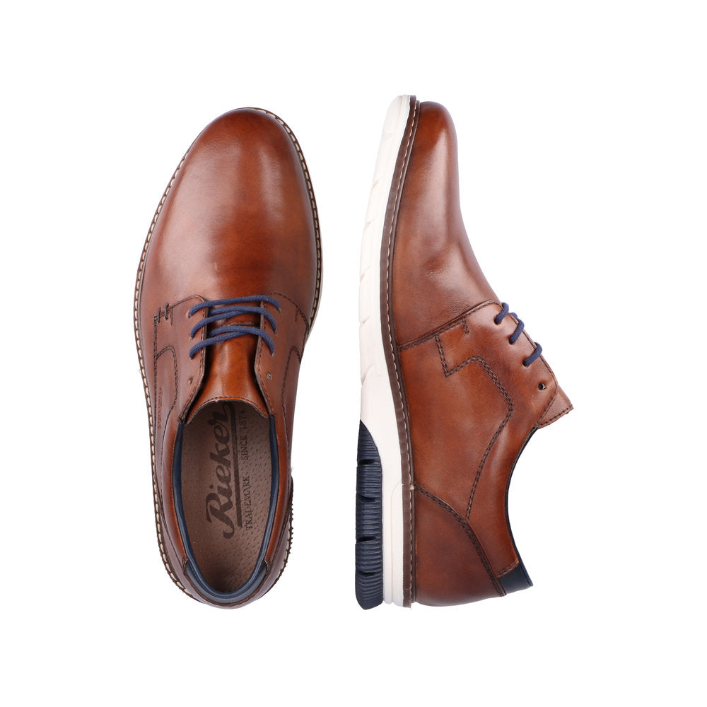 Et par 04906 Rieker Peanut Antistress brune dresssko fra Rieker Comfort & Style, med marineblå lisser og hvite såler, vist ovenfra og fra siden på hvit bakgrunn.
