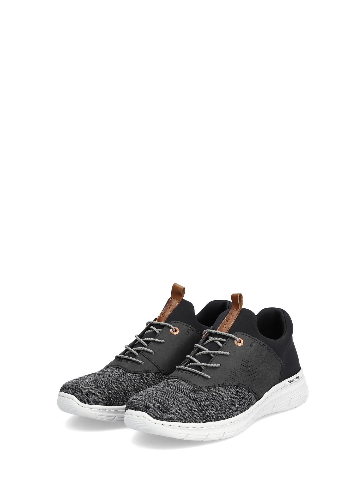 07528 Rieker Lightweight Slip-in Sneaker Black fra Rieker Comfort & Style har støtdempende såle, hvite såler, mønstret mesh-overdel og brune trekkfliker på pløsen, vist mot en vanlig hvit bakgrunn.