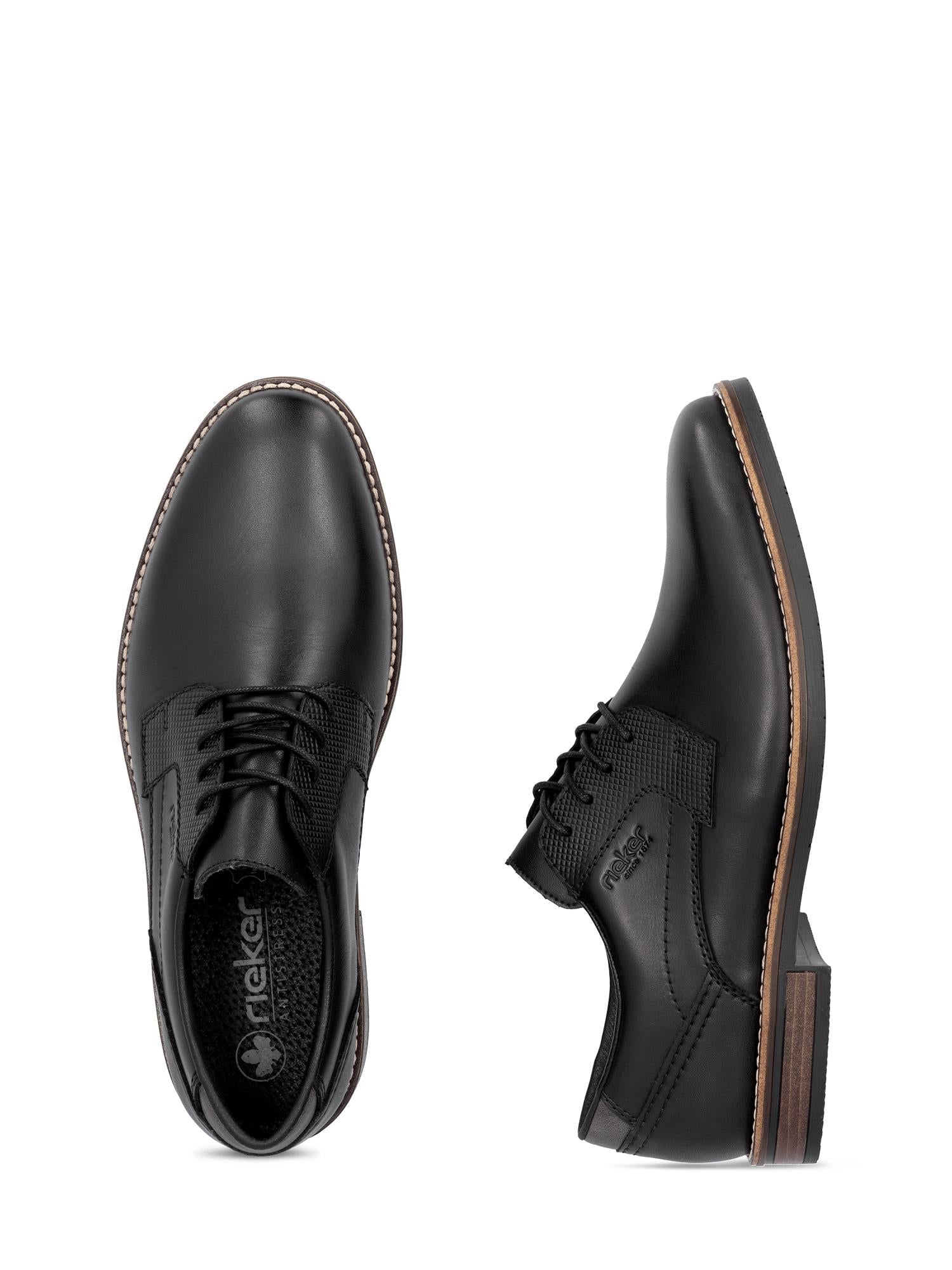 Et par 04934 Rieker Classic Leather Black dressko fra Rieker Comfort & Style med snørebånd og brunsvart lagdelt såle. Den ene skoen er vist ovenfra for å fremheve lissene, den andre fra siden for å vise detaljene i sålen.