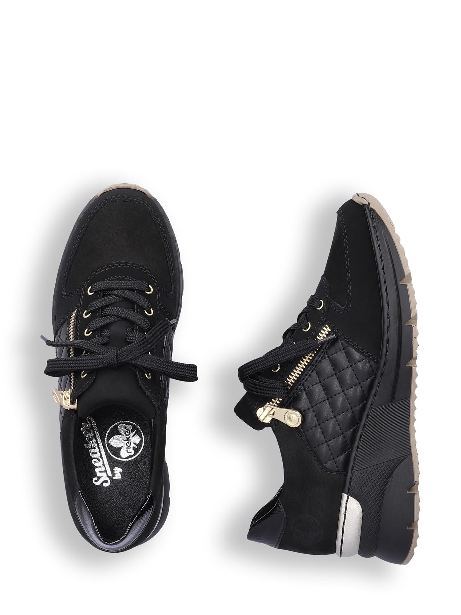 04389 Rieker Schwarz Kilesneakers fra Rieker Comfort & Style har svart overdel, glidelåser i gull og vatterte sider. Den ene skoen står oppreist, mens den andre ligger på siden og viser frem sålen og det fasjonable designet.