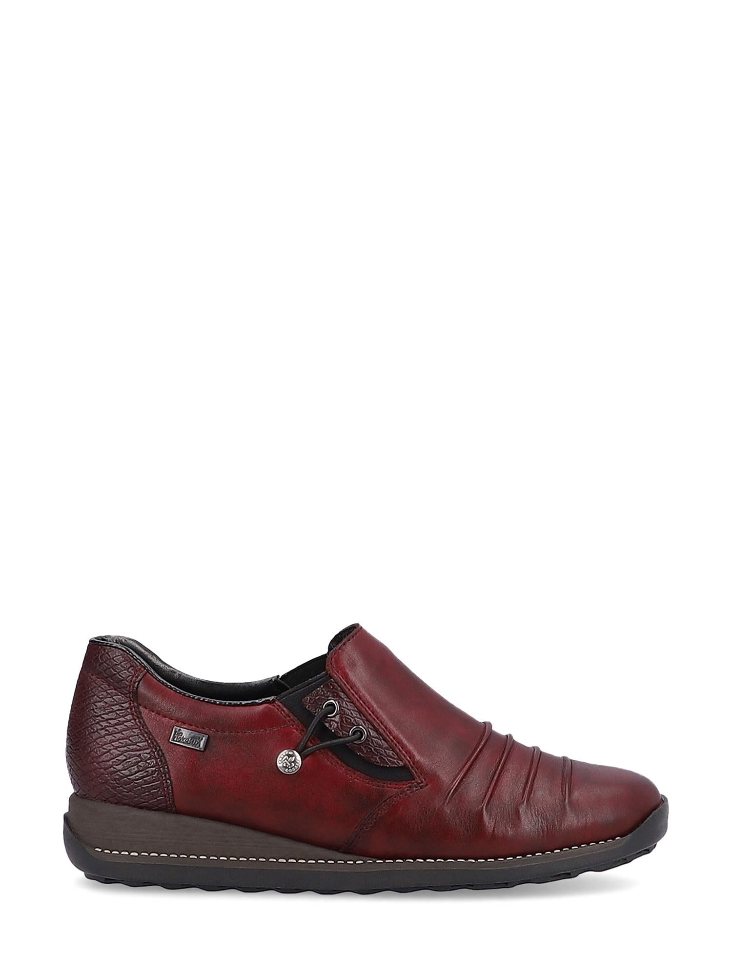 Bildet viser 04373 Rieker Vino Spasersko Tex-membran fra Rieker Comfort & Style: en burgunderfarget slip-on-sko i skinn med ekte skinn, sydde detaljer, teksturert hæl, metalldetaljer, antistress-teknologi og en svart gummisåle på hvitt.