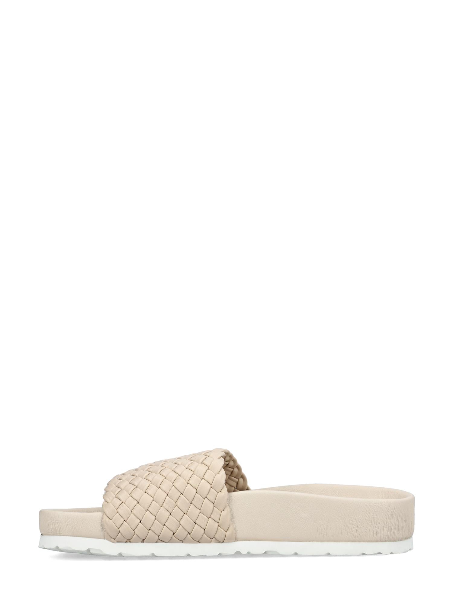 08093 Rieker Ginger Braid Sandal fra Rieker Comfort & Style er en beige sandal med vevd rem og flat, hvit såle, med Komfort- og Antistress-teknologi for komfort hele dagen. Vist i sideprofil på en ensfarget hvit bakgrunn.