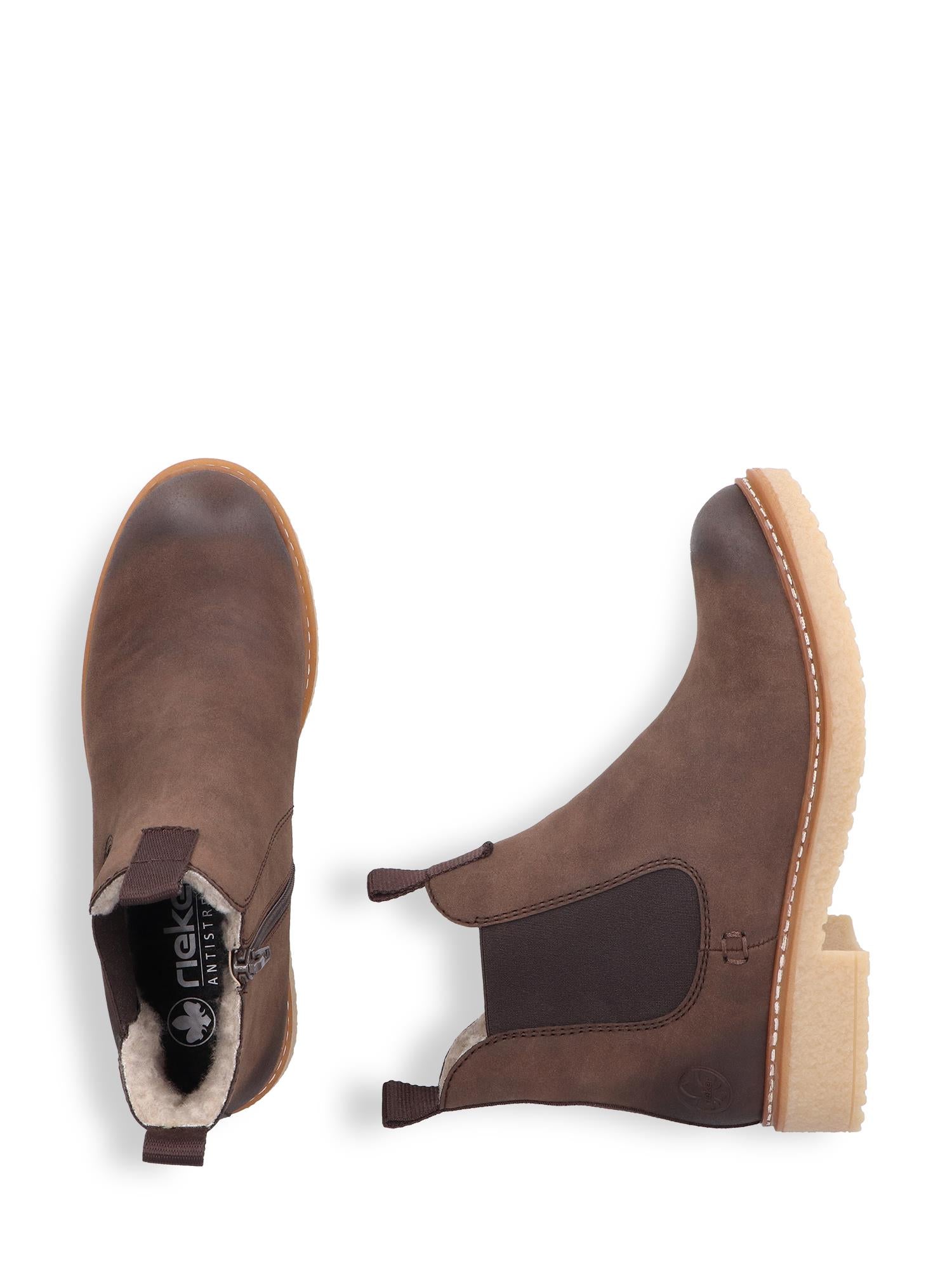 04947 Rieker Brown low chelsea varmfôret boots fra Rieker Comfort & Style har brunt skinn, elastiske sidepaneler, lysebrune yttersåler, koselig shearlingfôr og antistress-komfort. Vist ovenfra og fra siden på en hvit bakgrunn.