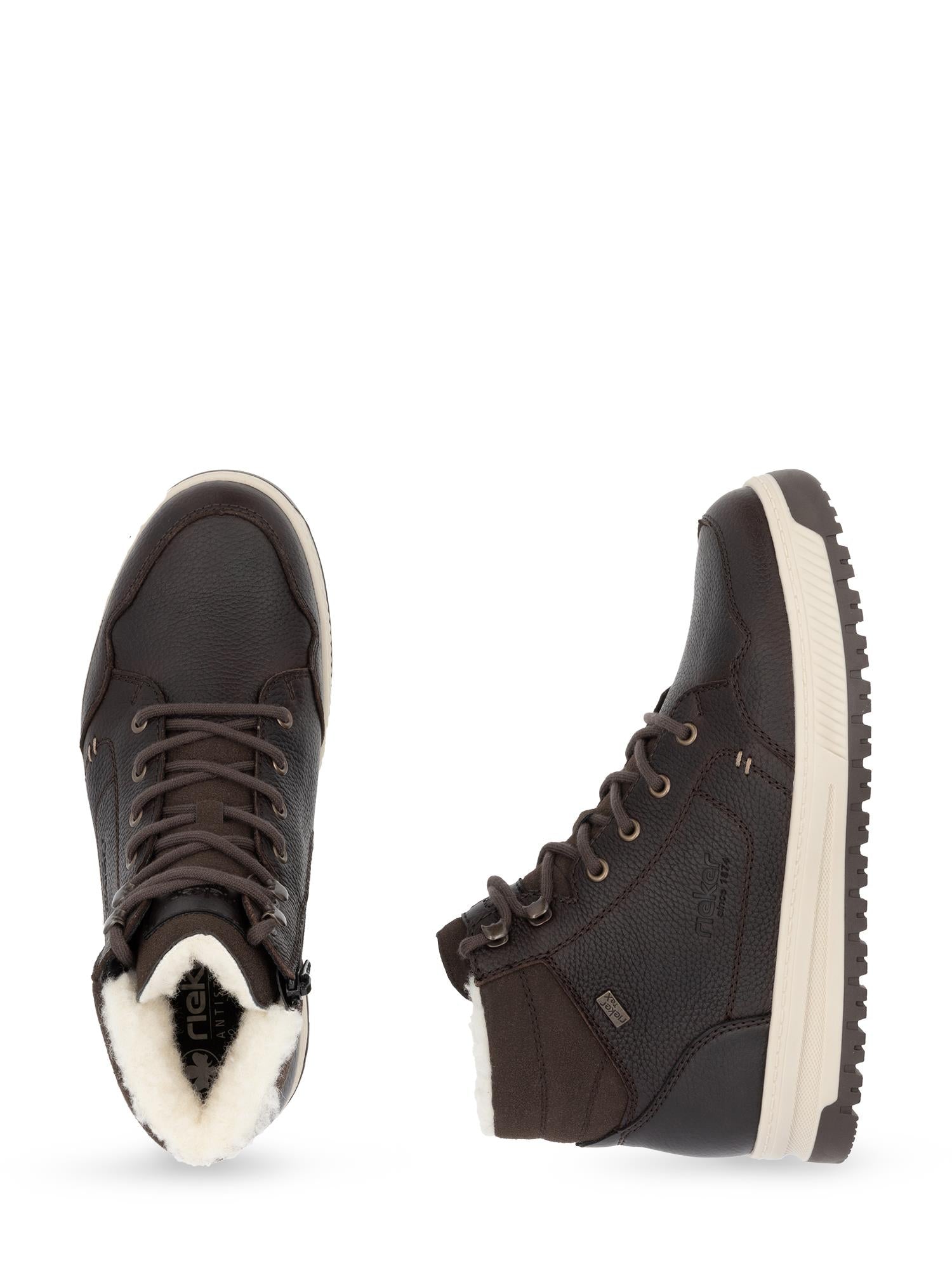 04839 Rieker Winter Tex-Membran Boot fra Rieker Comfort & Style har en mørkebrun, høy topp, kremfarget såle, hvitt fleecefôr, ekstra bred passform og vannavvisende materiale som holder føttene varme og tørre hele sesongen.