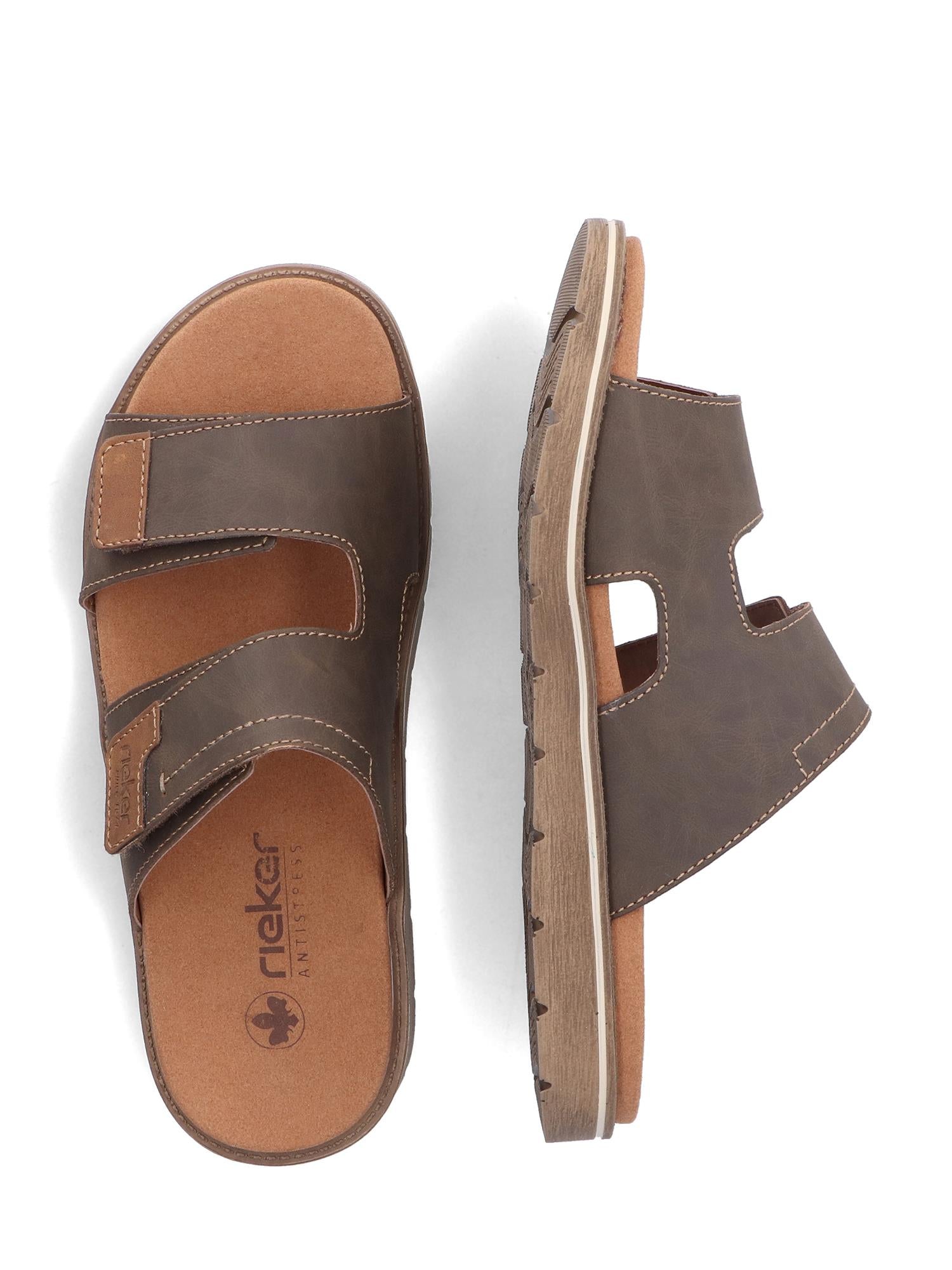 Et par 07490 Rieker 24394-25 brune Rieker Comfort & Style slide herretøfler med åpen tå i skinn, med to brede reimer og en polstret antistress-fotseng, vist fra oven og fra siden mot en hvit bakgrunn.