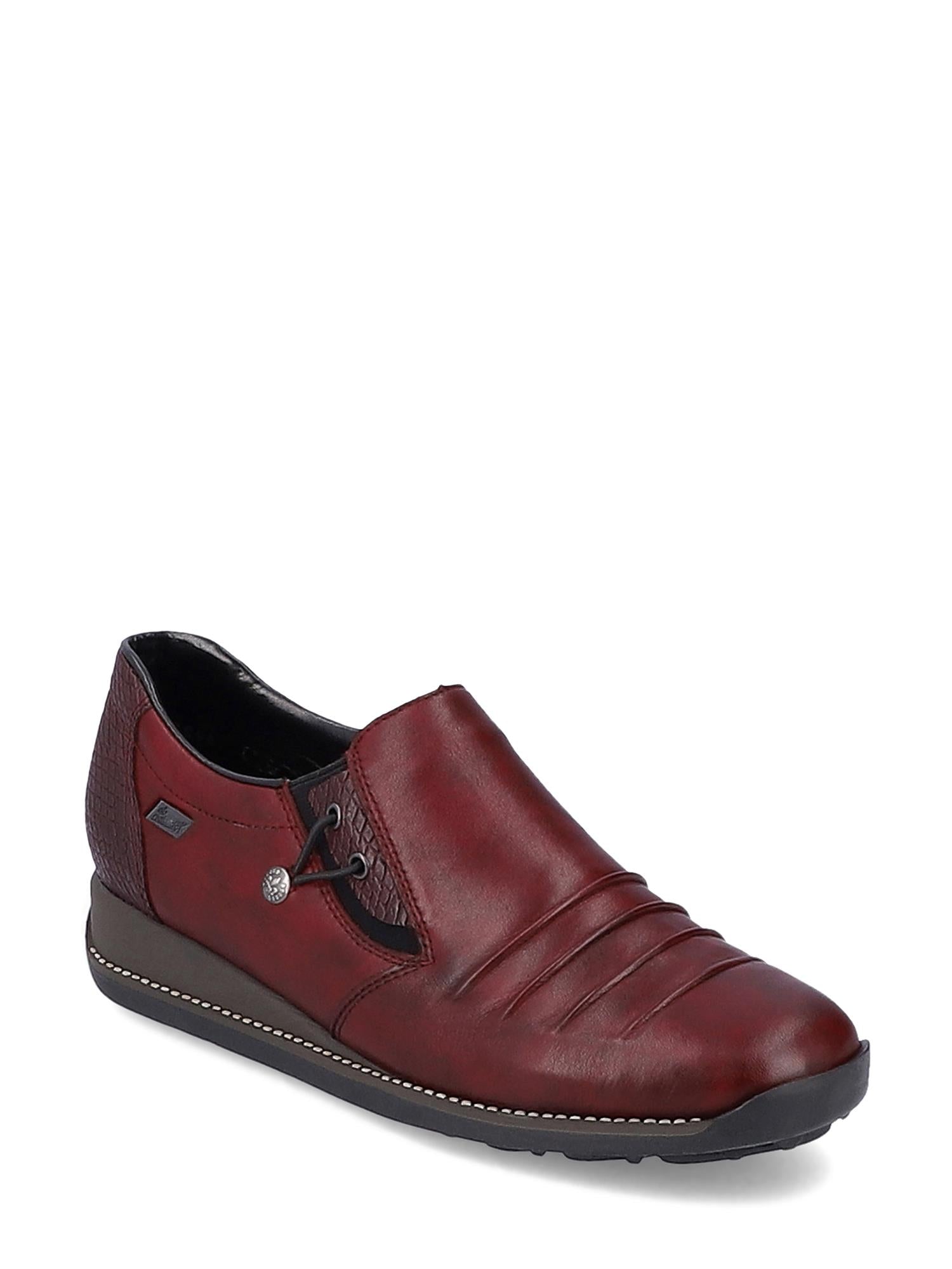 04373 Rieker Vino Spasersko Tex-membran fra Rieker Comfort & Style er en burgunderfarget slip-on i skinn med svart såle, søm foran, dekorativ snøring med metallknapp og Antistress-teknologi for avslappet komfort hele dagen.