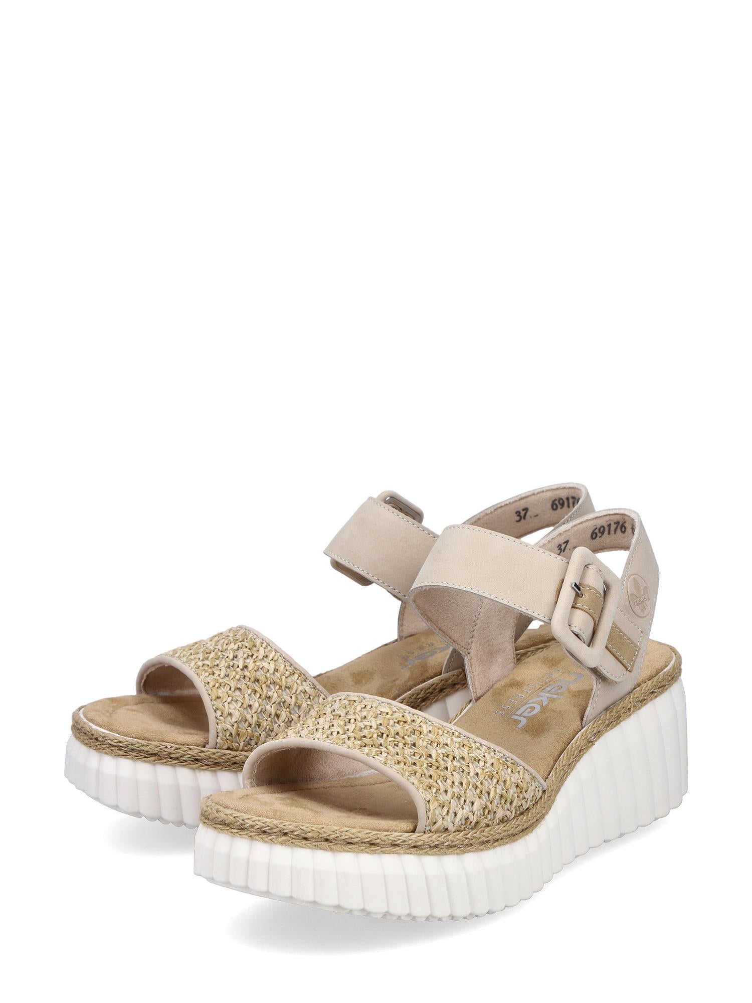 03047 Rieker Celensa Sandal Beige fra Rieker Comfort & Style har kilehæl, flettede stropper med stråstruktur foran, vriststropp med spenne og tykke, hvite, ribbede platåsåler, vist mot en hvit bakgrunn.