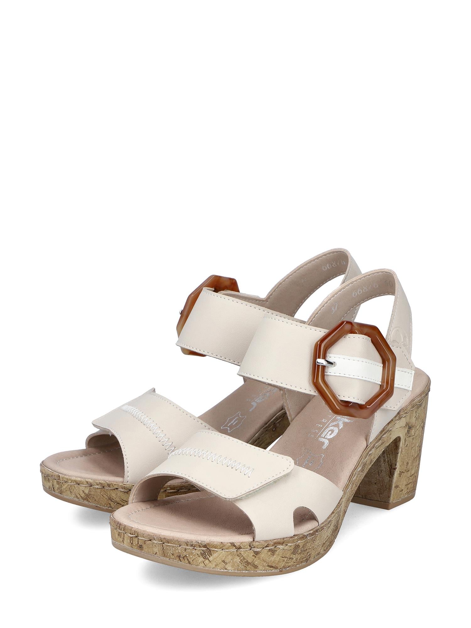 07639 Rieker Tropical High Sandal fra Rieker Comfort & Style har kremfargede brede reimer, store brune sekskantede spenner, en blokkhæl med korkstruktur, synlige sømmer, åpne tær og antistress-teknologi som gir komfort hele dagen.
