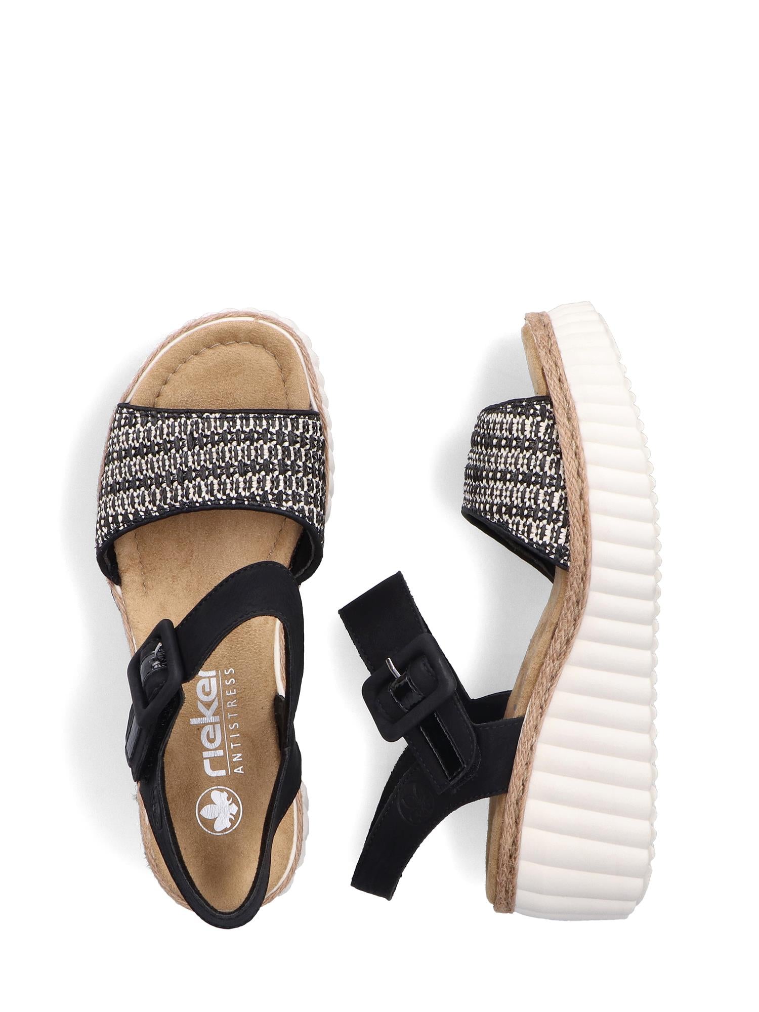 03025 Rieker Celensa Sandal fra Rieker Comfort & Style har svarte, hvite og beige vevde reimer, svarte ankelreimer med spenne, solbrune fotsenger, tykke hvite såler med riller og komfortbredde G.