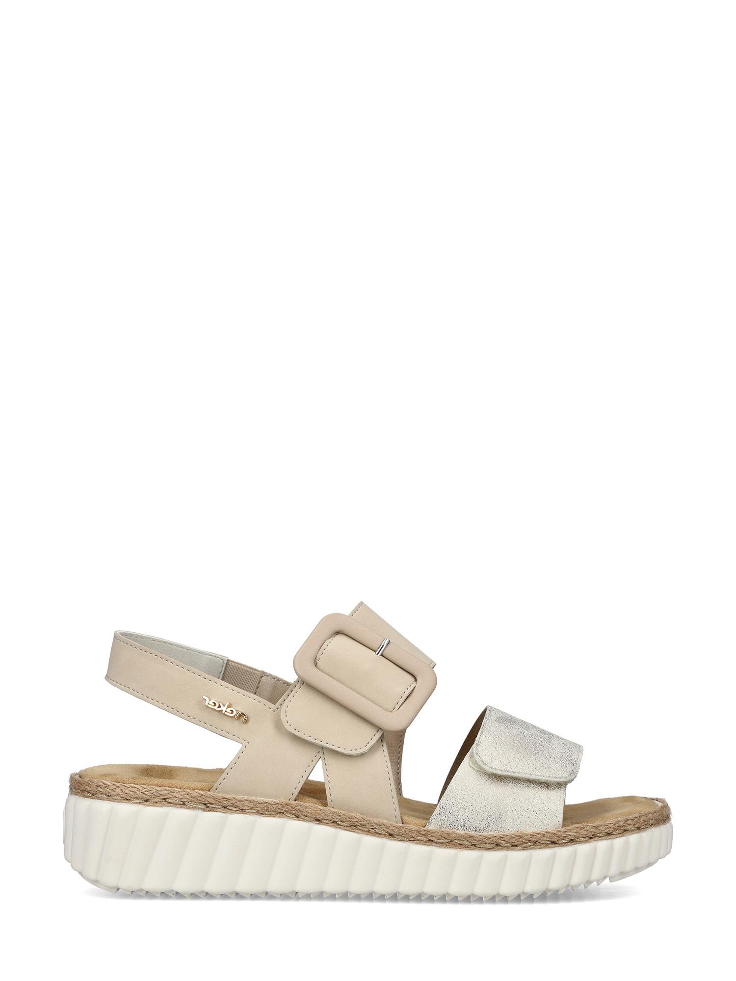 02173 Rieker Beige Breeze Sandal fra Rieker Comfort & Style har en overdel i beige og sølvfarget metallic, tykk hvit såle med riller, stor sidespenne, åpen tå, slingback-hælrem og vevde jute-detaljer over yttersålen.